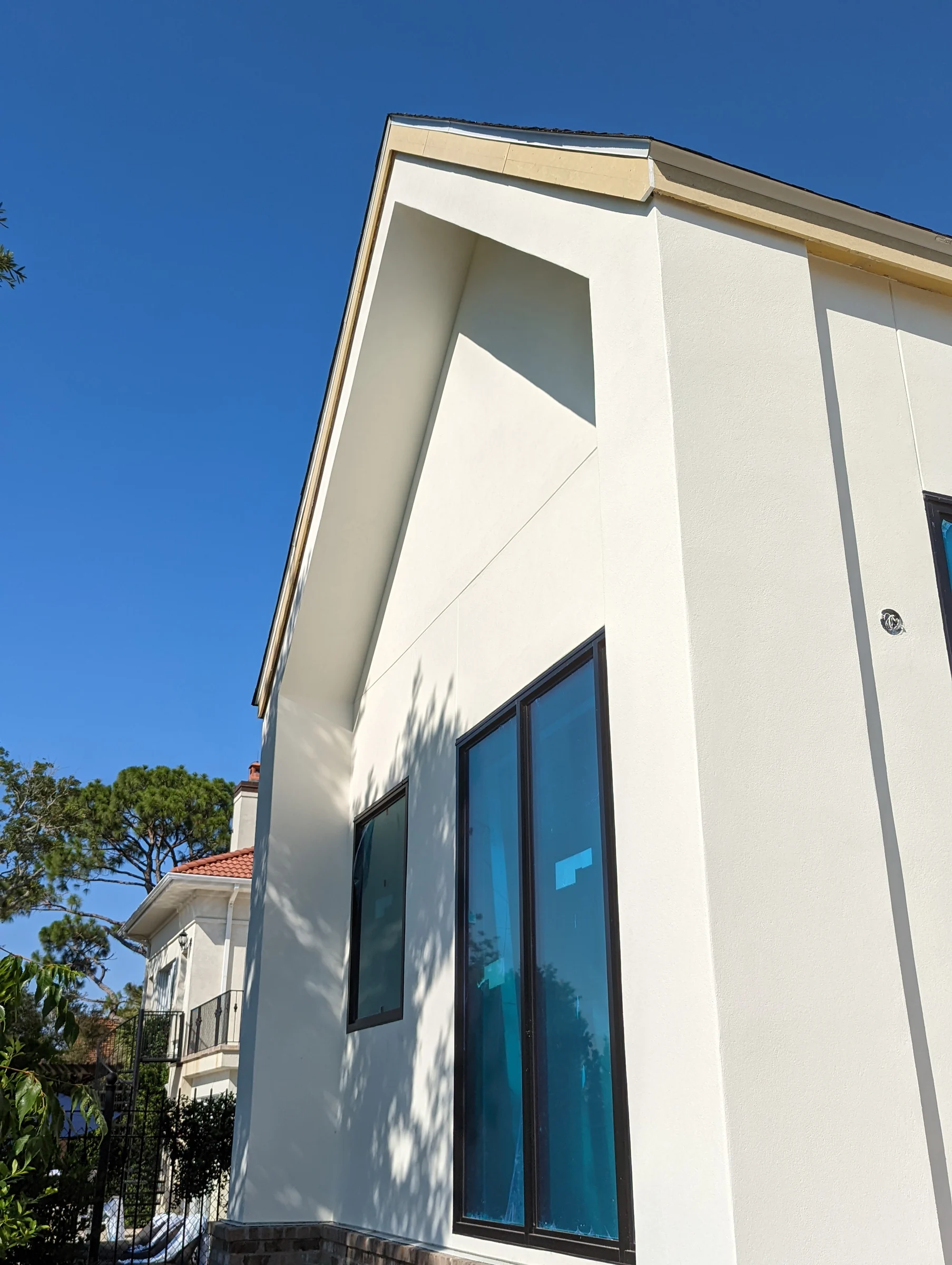 Angular white wall with tall window and roofline