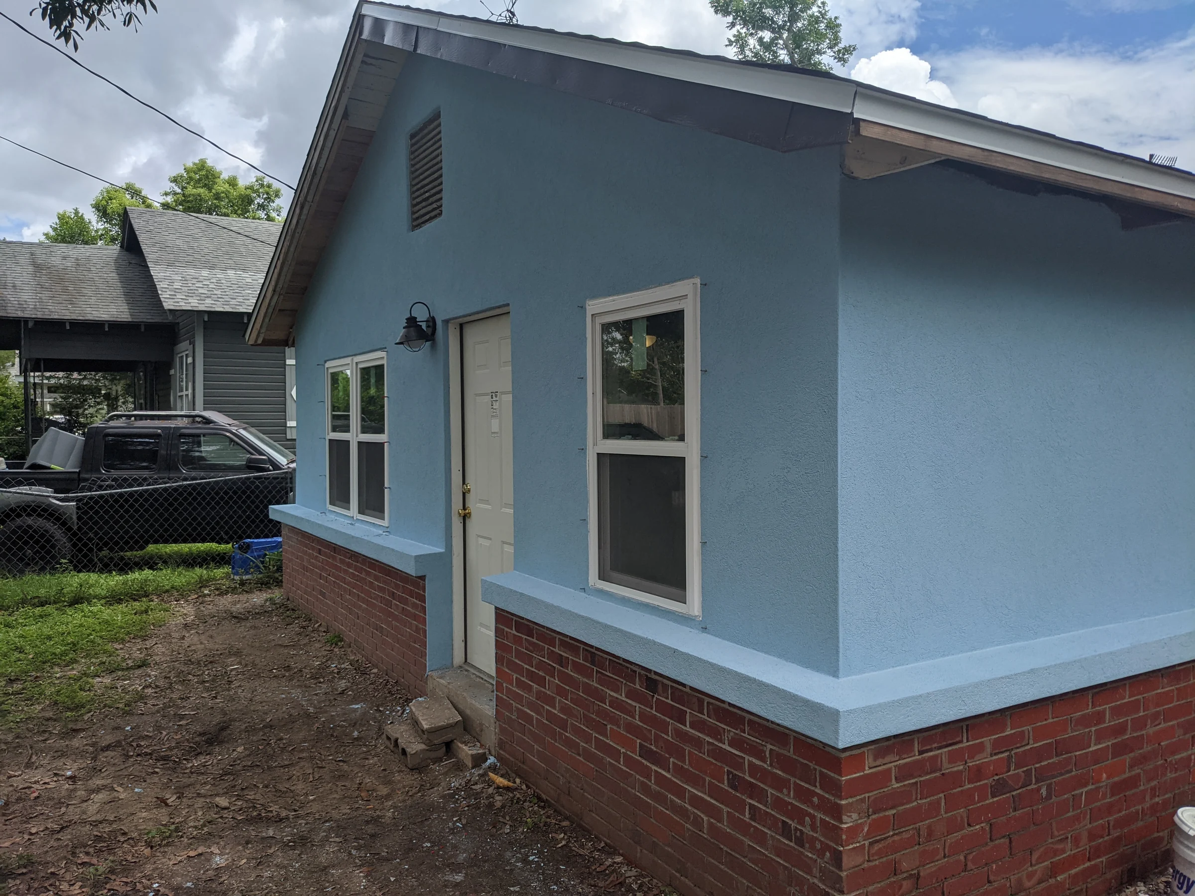 Blue house exterior with a brick base and white trim