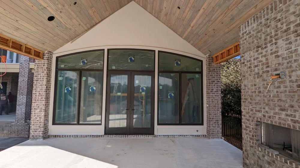 Covered patio with arched glass doors and brick walls