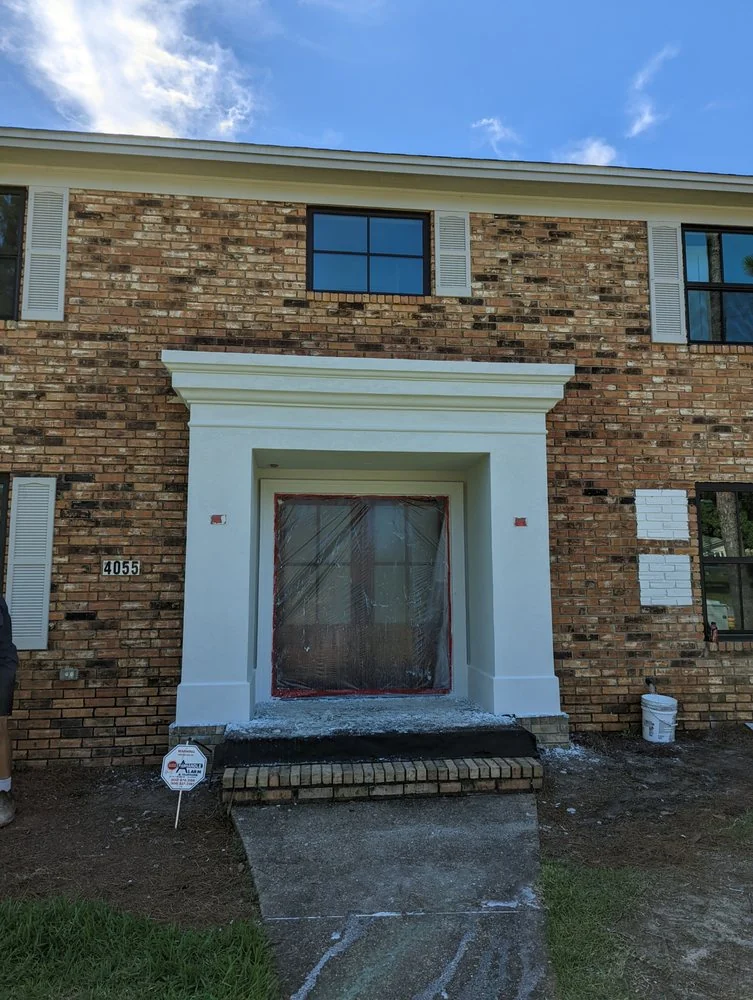 Stone-clad wall with a window and light-colored trim