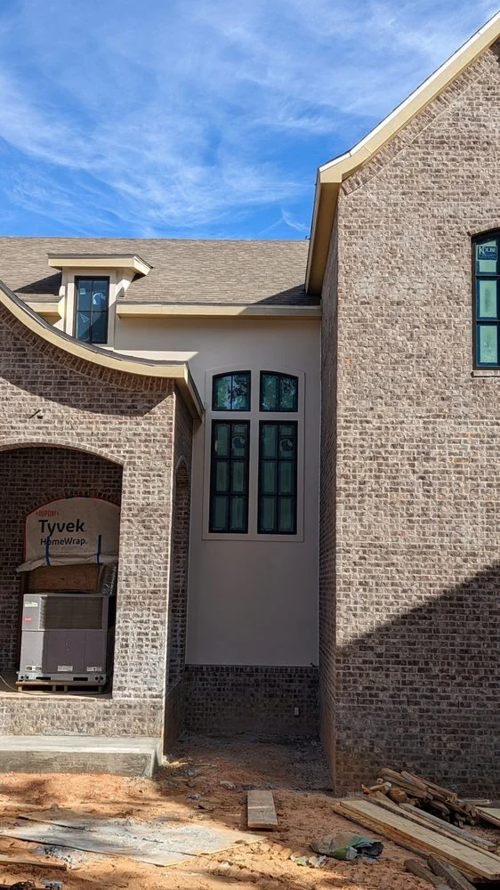 Arched entry beside a light-colored house