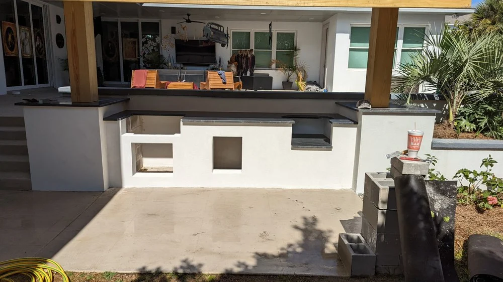 Outdoor counter area with cabinets and planters